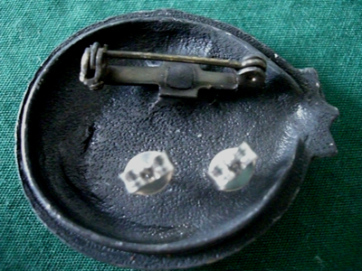 There is a pin on the other side of the lid. The lid is also a brooch.